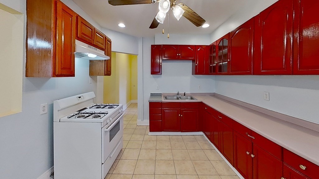 3 Dunlap Street Boston, MA 02124 - Photo 10 of 42 a kitchen with stainless steel appliances granite countertop a stove a sink and a microwave