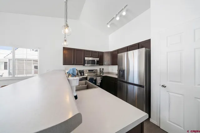 a kitchen with kitchen island a counter top space stainless steel appliances and cabinets