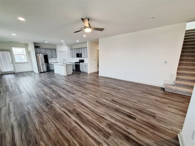 a kitchen with stainless steel appliances kitchen island granite countertop a stove a sink and a refrigerator