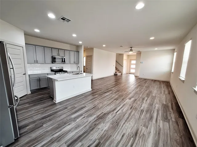a kitchen with granite countertop a sink stove and refrigerator