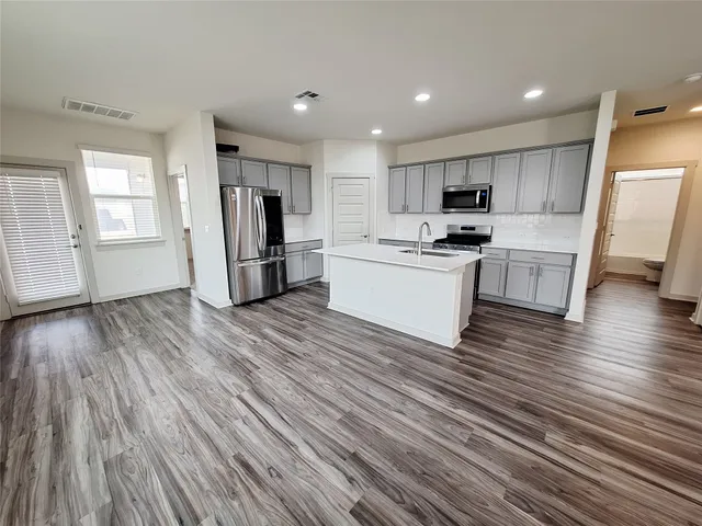 a kitchen with granite countertop white cabinets and stainless steel appliances
