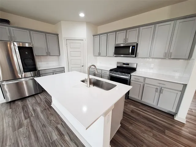a kitchen with cabinets and wooden floor