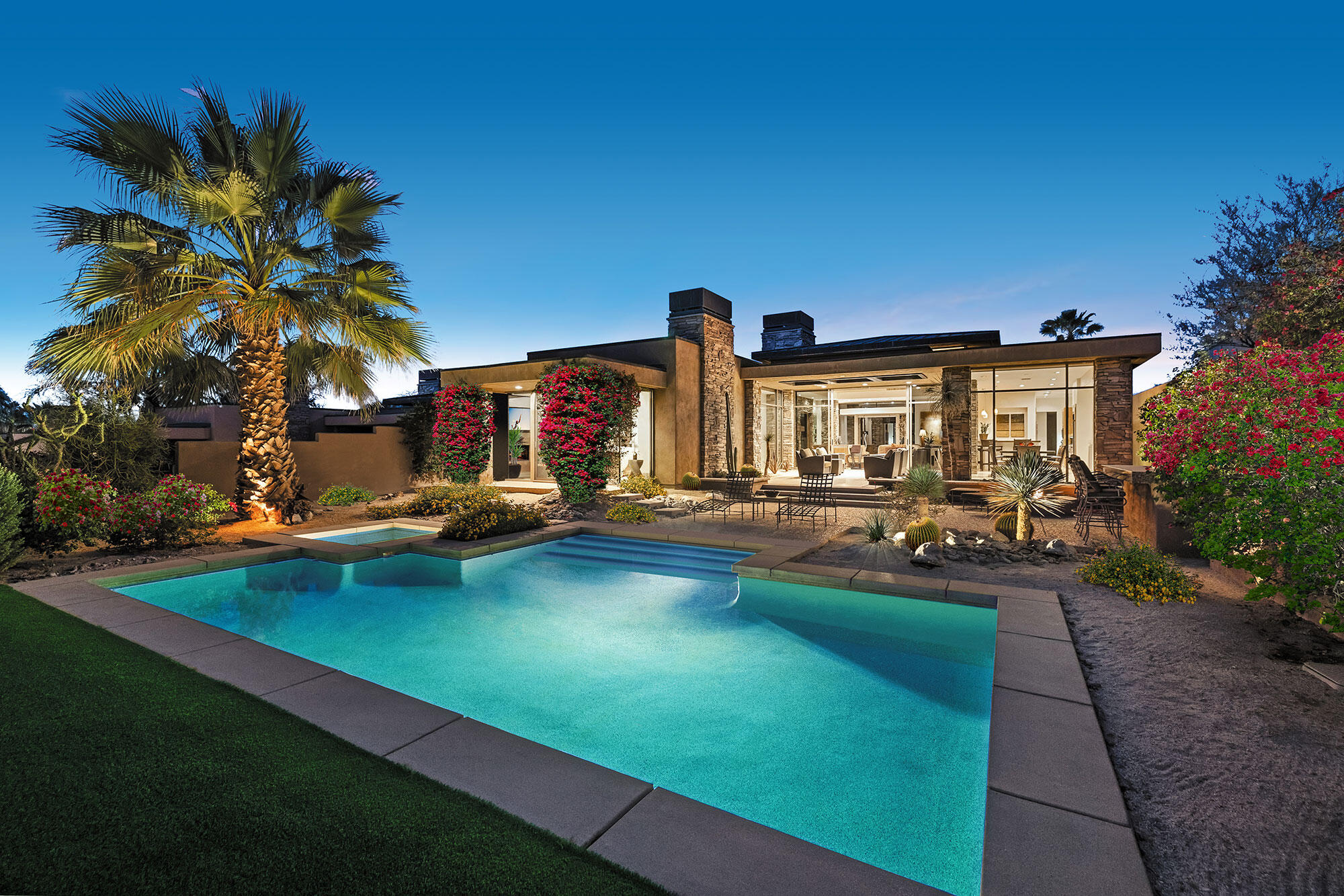 a view of swimming pool with outdoor seating and house in the background