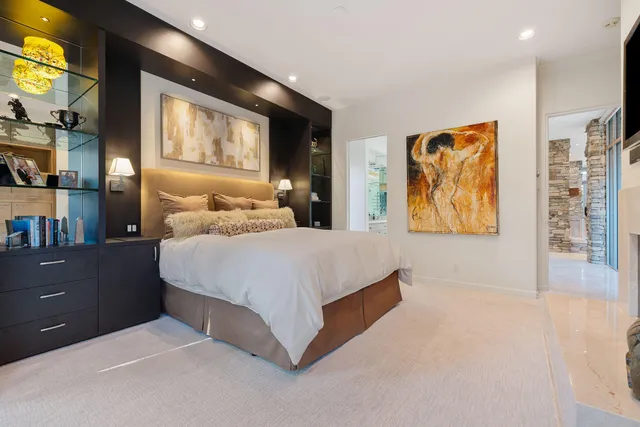 a bedroom with a bed and painting on the wall