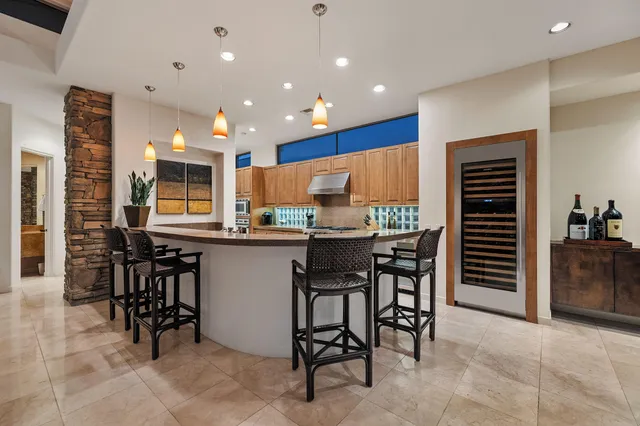 a kitchen with stainless steel appliances kitchen island granite countertop a table and chairs in it