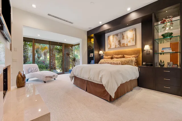 a bedroom with a large bed and large windows