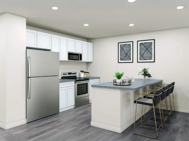 a kitchen with a refrigerator and a stove top oven