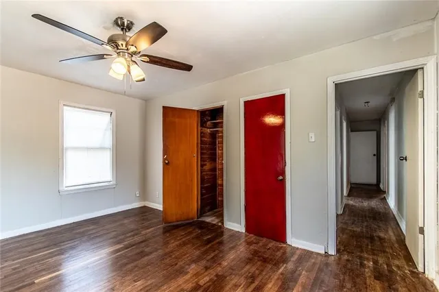 a view of an empty room with window and wooden floor