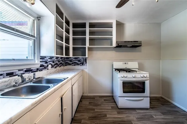 a kitchen with stainless steel appliances a stove a sink and a microwave