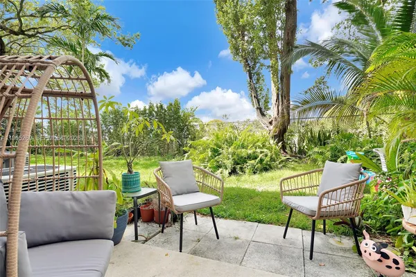 a view of a chairs and table in the back yard of the house