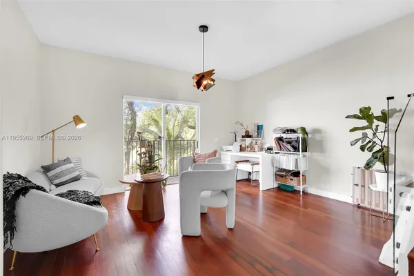 a living room with furniture and a wooden floor