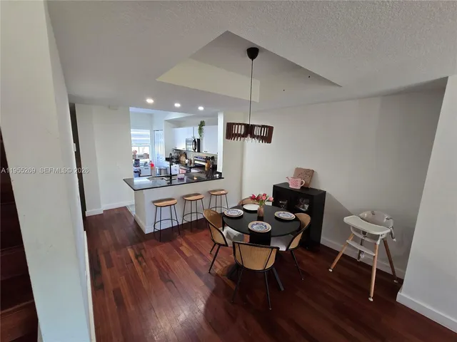 a kitchen with a dining table chairs and white cabinets