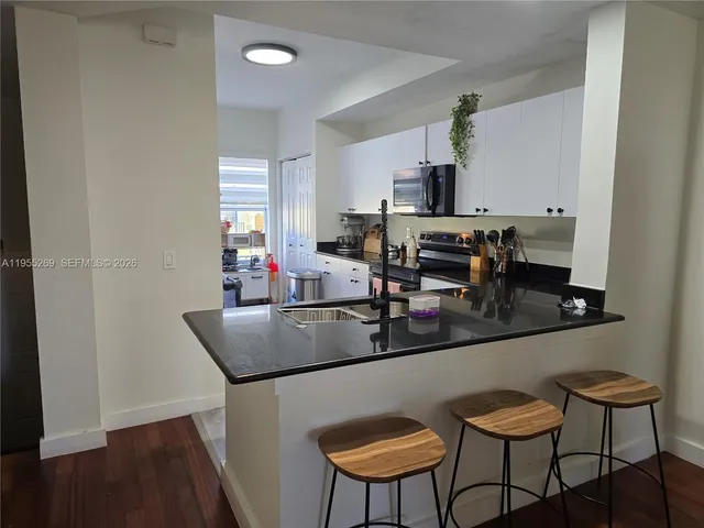 a kitchen with stainless steel appliances granite countertop a sink and a refrigerator