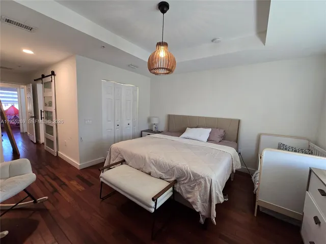 a bedroom with bed and wooden floor