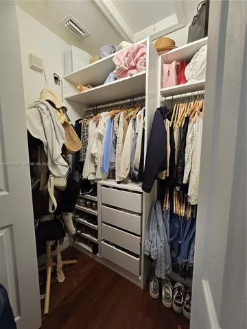 a view of walk in closet with clothes and shoes
