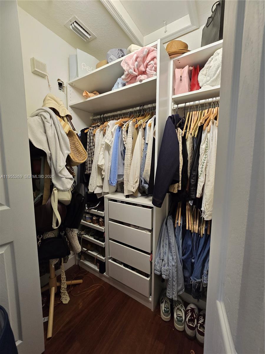 738 Northeast 90th Street, Unit 207 Miami, FL 33138 - Photo 8 of 19 a view of walk in closet with clothes and shoes