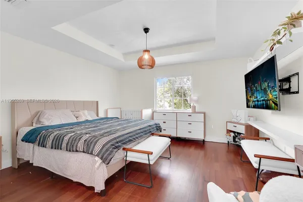 a bedroom with a bed and a flat tv screen on dresser