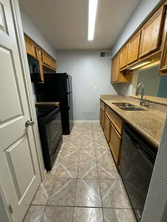 a kitchen with granite countertop a stove top oven and sink
