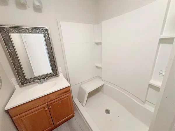 a bathroom with a tub sink and mirror