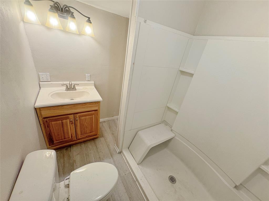 211 Oak Street Roscoe, TX 79545 - Photo 18 of 22 a bathroom with a sink a toilet and mirror