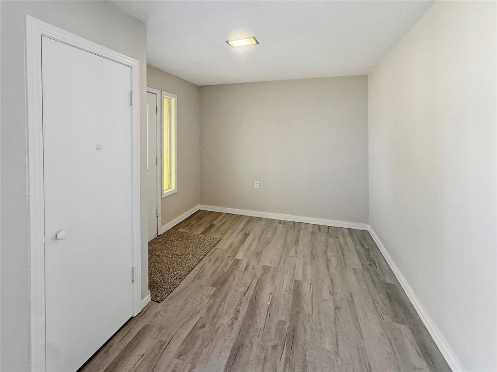 211 Oak Street Roscoe, TX 79545 - Photo 6 of 22 an empty room with wooden floor and windows