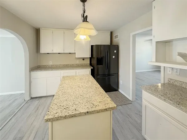 a kitchen with granite countertop a refrigerator and a sink