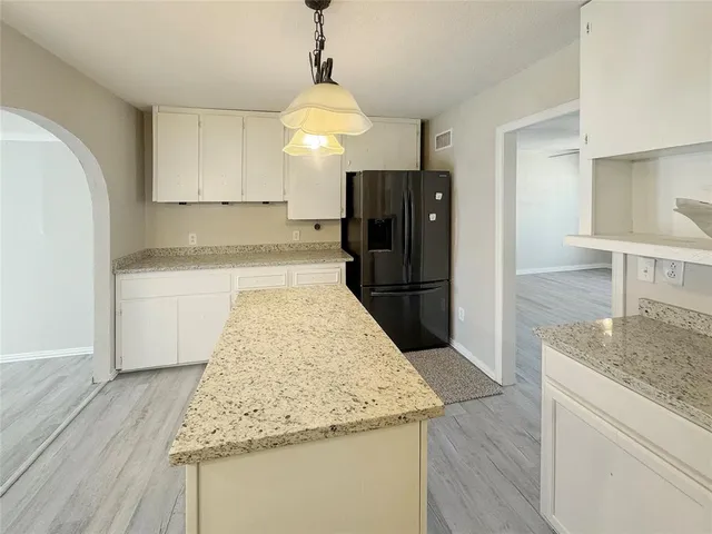 a kitchen with granite countertop a refrigerator and a sink