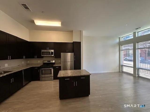 a kitchen with stainless steel appliances granite countertop a stove a sink and a refrigerator