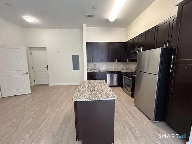 a kitchen with granite countertop a refrigerator and a sink