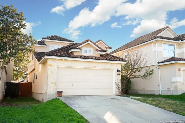 a view of a white house with a yard and a large tree
