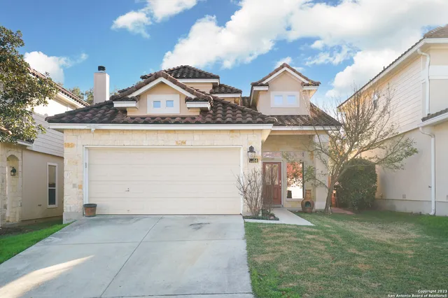 a view of a white house next to a yard and road