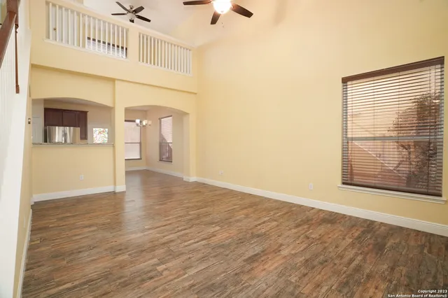 a view of an empty room with a window and wooden floor