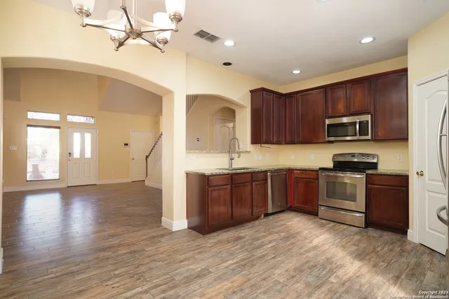 a open kitchen with stainless steel appliances granite countertop a stove cabinets and wooden floor