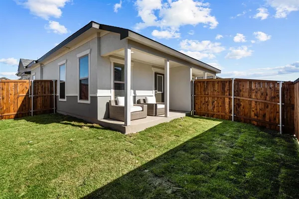 a view of backyard with potted plants and wooden fence