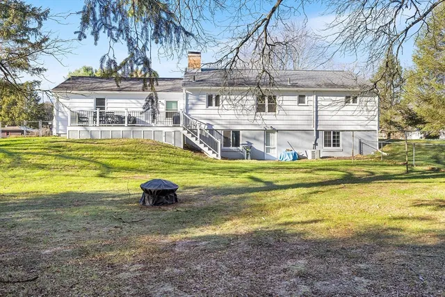a view of a house with a big yard and large trees