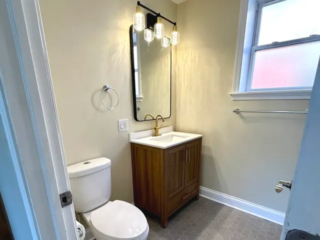a bathroom with a toilet sink and mirror
