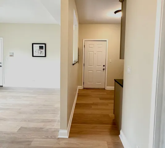 a view of a hallway with wooden floor