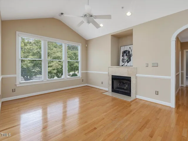 wooden floor fireplace and windows in an empty room