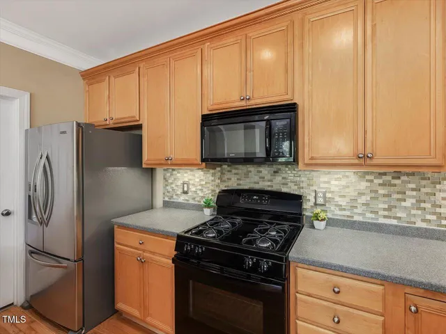 a kitchen with granite countertop a refrigerator stove and microwave