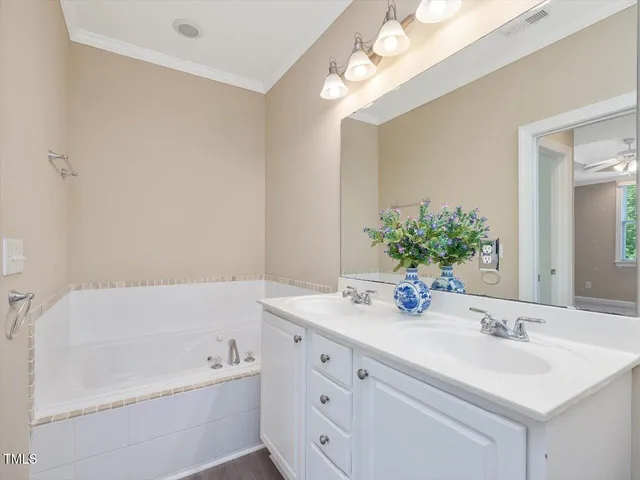 a bathroom with a tub a sink and mirror