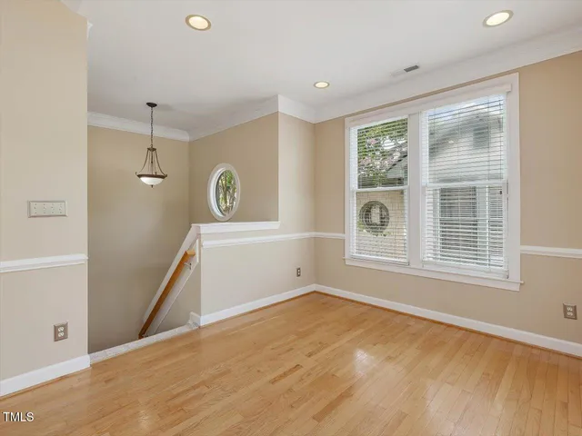 a view of empty room with wooden floor and fireplace