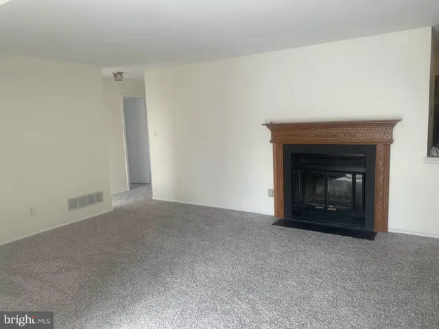 a view of an empty room with a fireplace