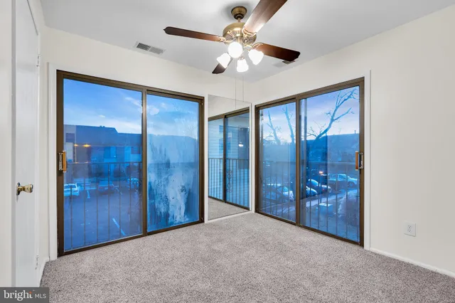 an empty room with fan and windows