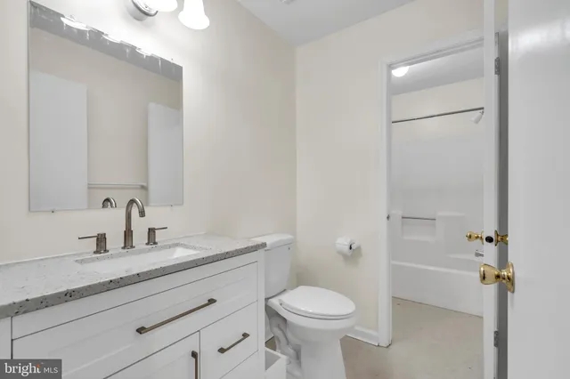 a bathroom with a sink a toilet and a mirror