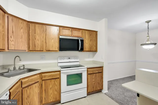 a kitchen with stainless steel appliances a stove microwave and sink