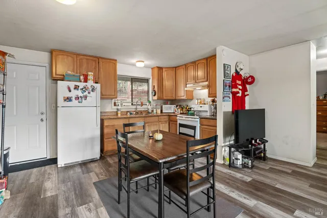 a view of a dining room with furniture a chandelier and wooden floor