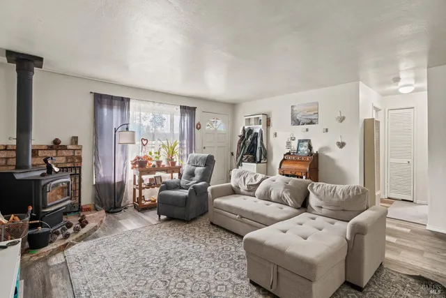 a living room with furniture a flat screen tv and a window