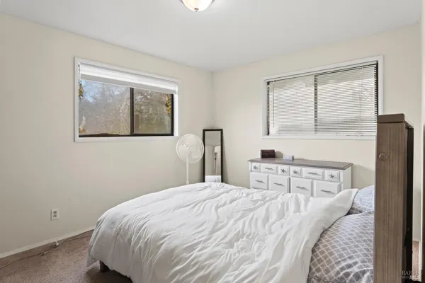 a bedroom with a bed and a painting on the wall