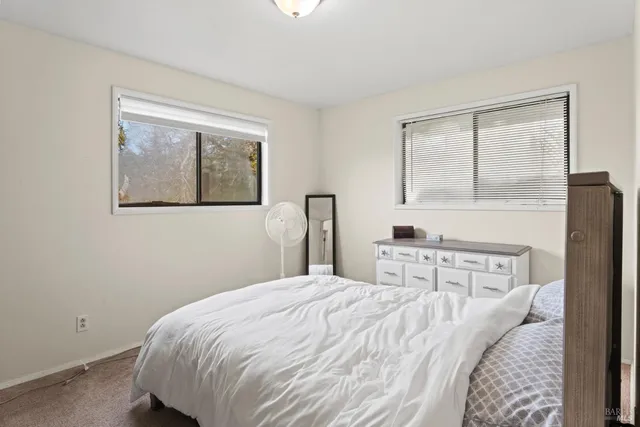 a bedroom with a bed and a painting on the wall