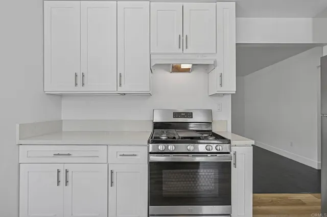 a kitchen with white cabinets and a stove top oven